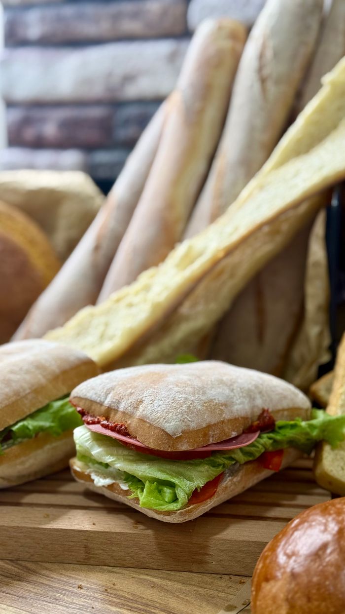 Assorted fresh breads and a sandwich with lettuce, perfect for breakfast or lunch.